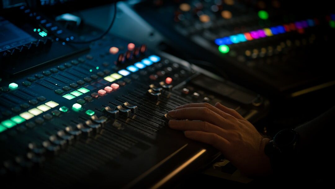 Hands operating an audio and video mixing console